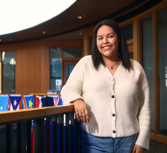 Женщина в футболке со звездой опирается на перила